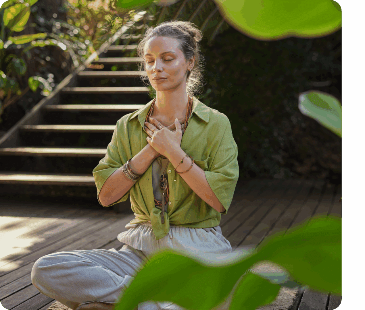 Woman meditating outdoors on wooden deck.
